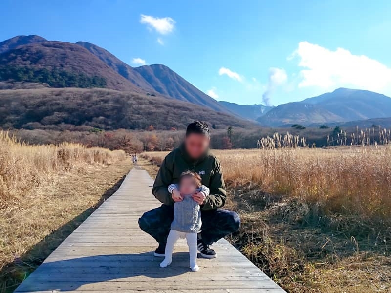 タデ原湿原で赤子と遊ぶ父親