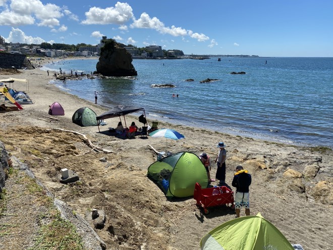 海にテントを立てて海水浴を楽しむ人達