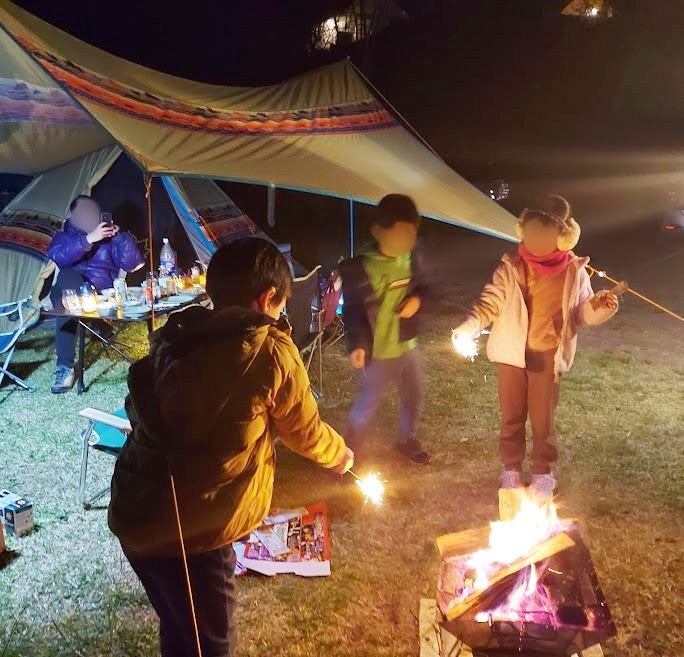 焚き火を囲んで花火を楽しむ子供達