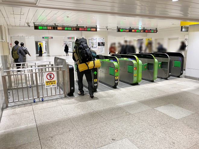 新宿駅の改札口を通る後ろ姿