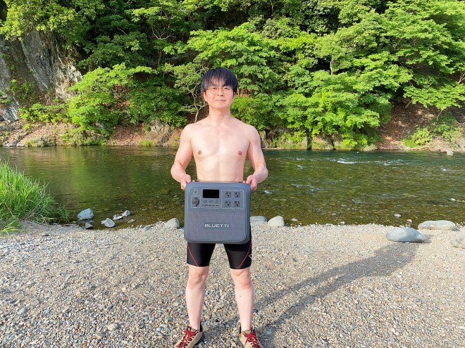 BLUETTI AC180を持つ水着姿の男