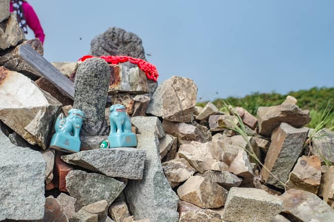 山頂標識の傍にあるケルンのように積まれた岩には三角点